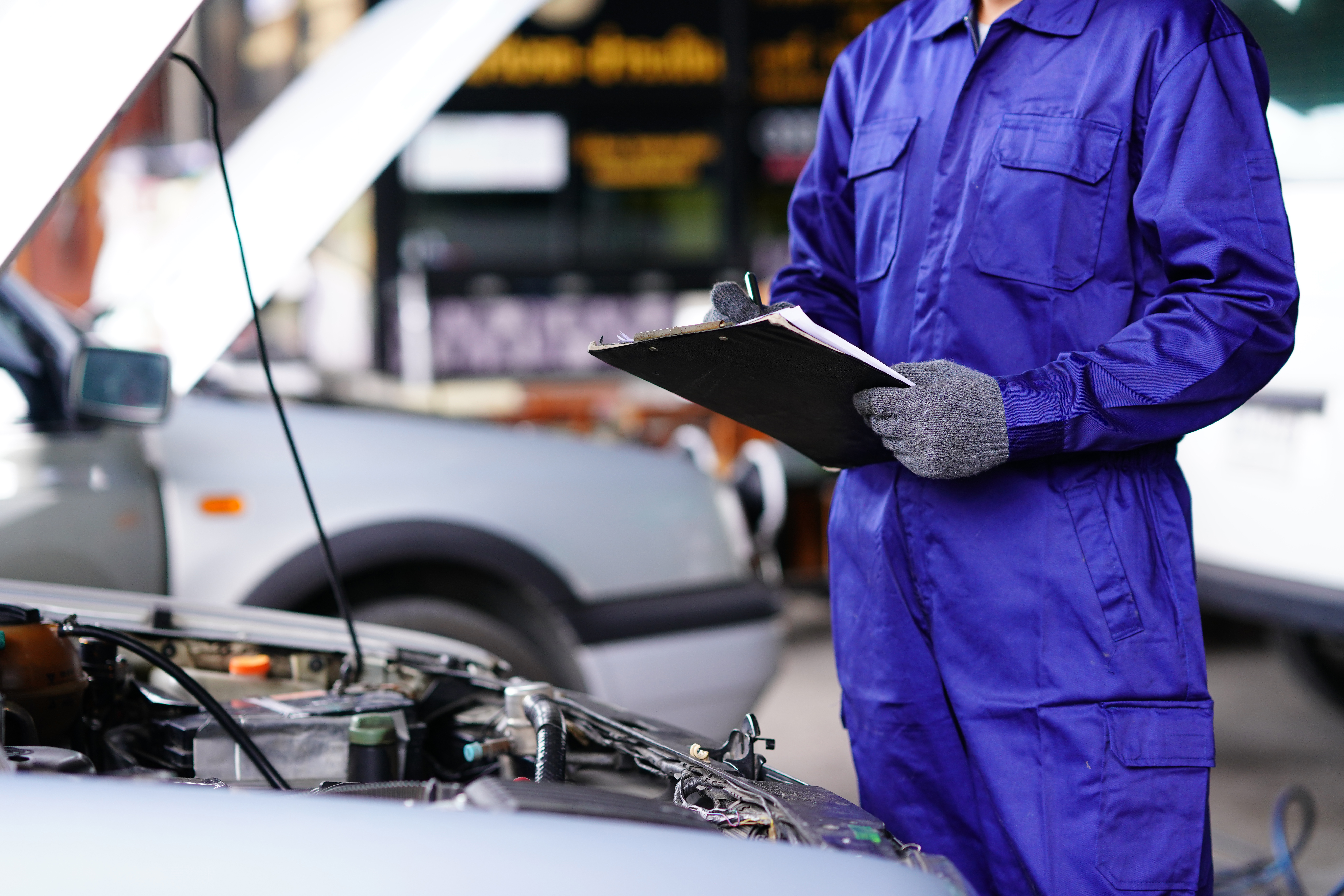 Automotive mechanic doing vehicle maintenance checklist